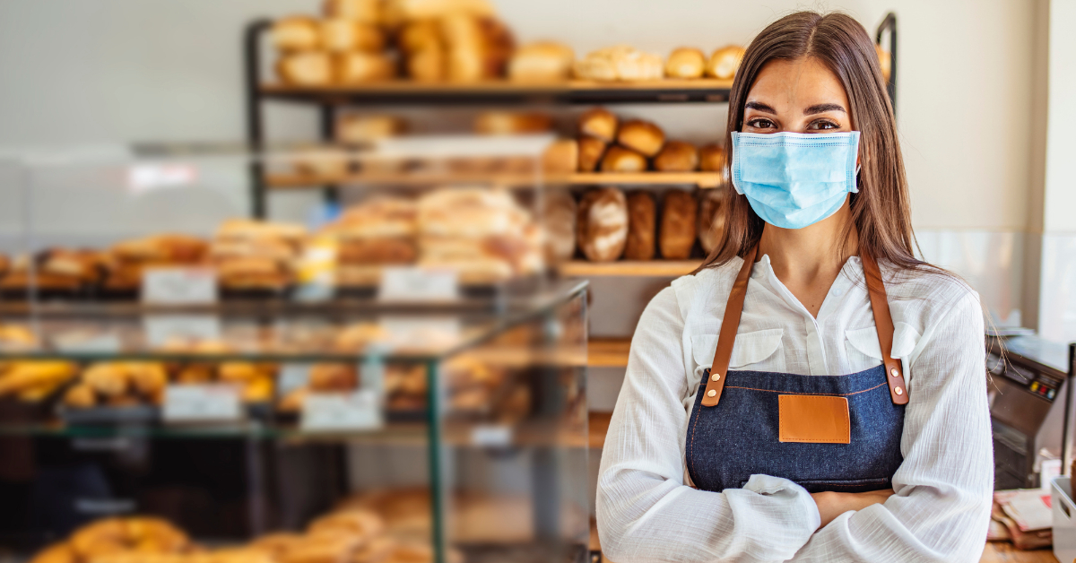 A retail employee stands at their storefront.